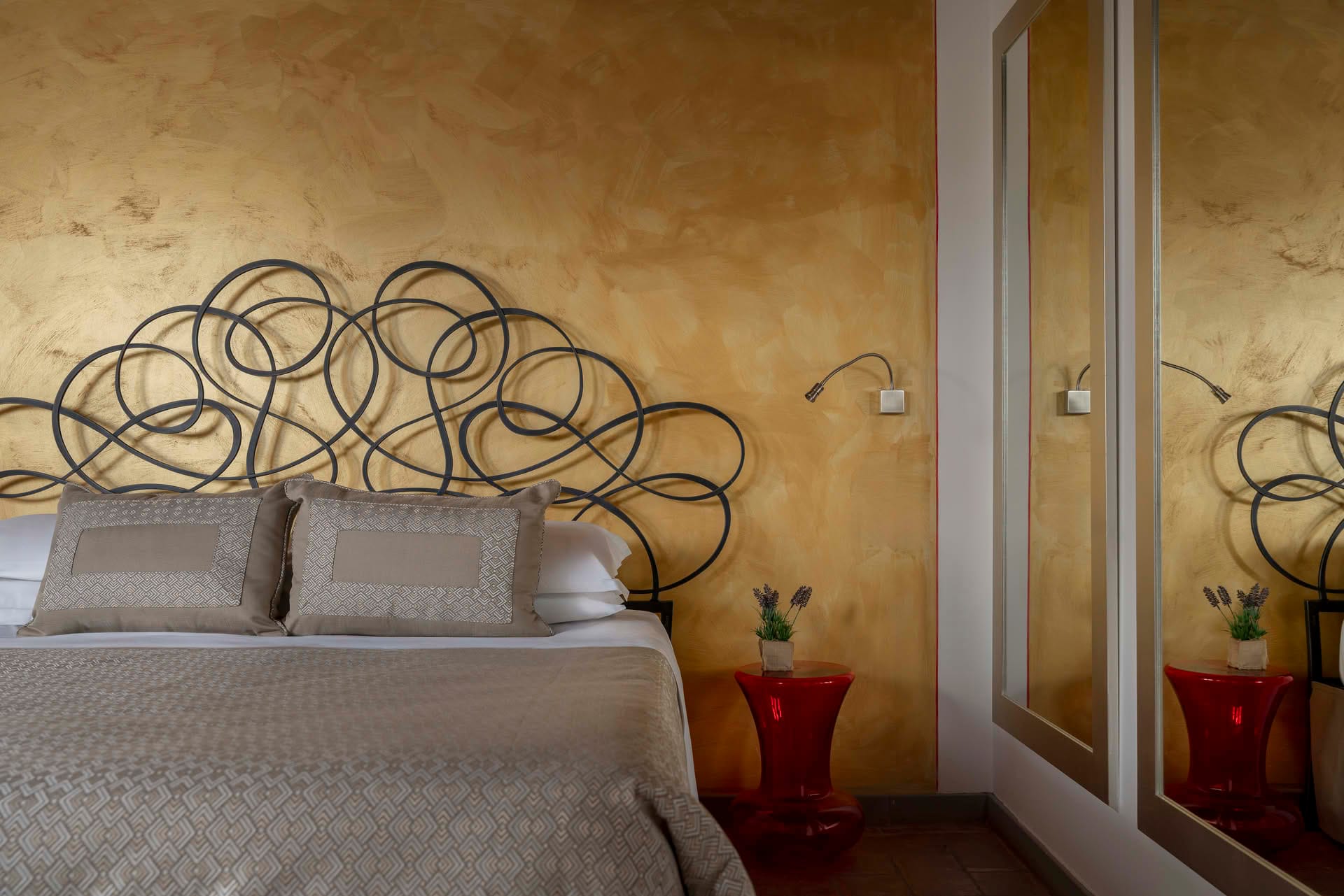 Detail of the double bed with wrought iron headboard in the Deluxe Room