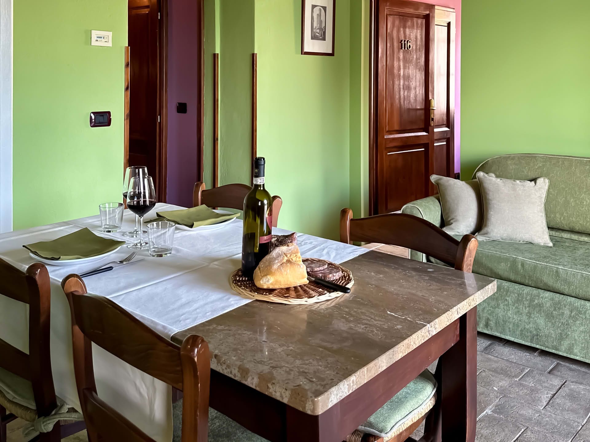 Detail of the dining area and sofa in the Leccio Apartment