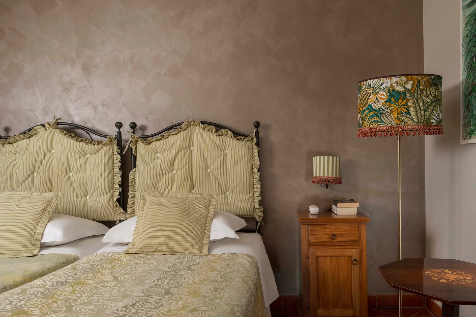 Detail of the double bed with bedside table in the Classic Room at Casolare Terre Rosse