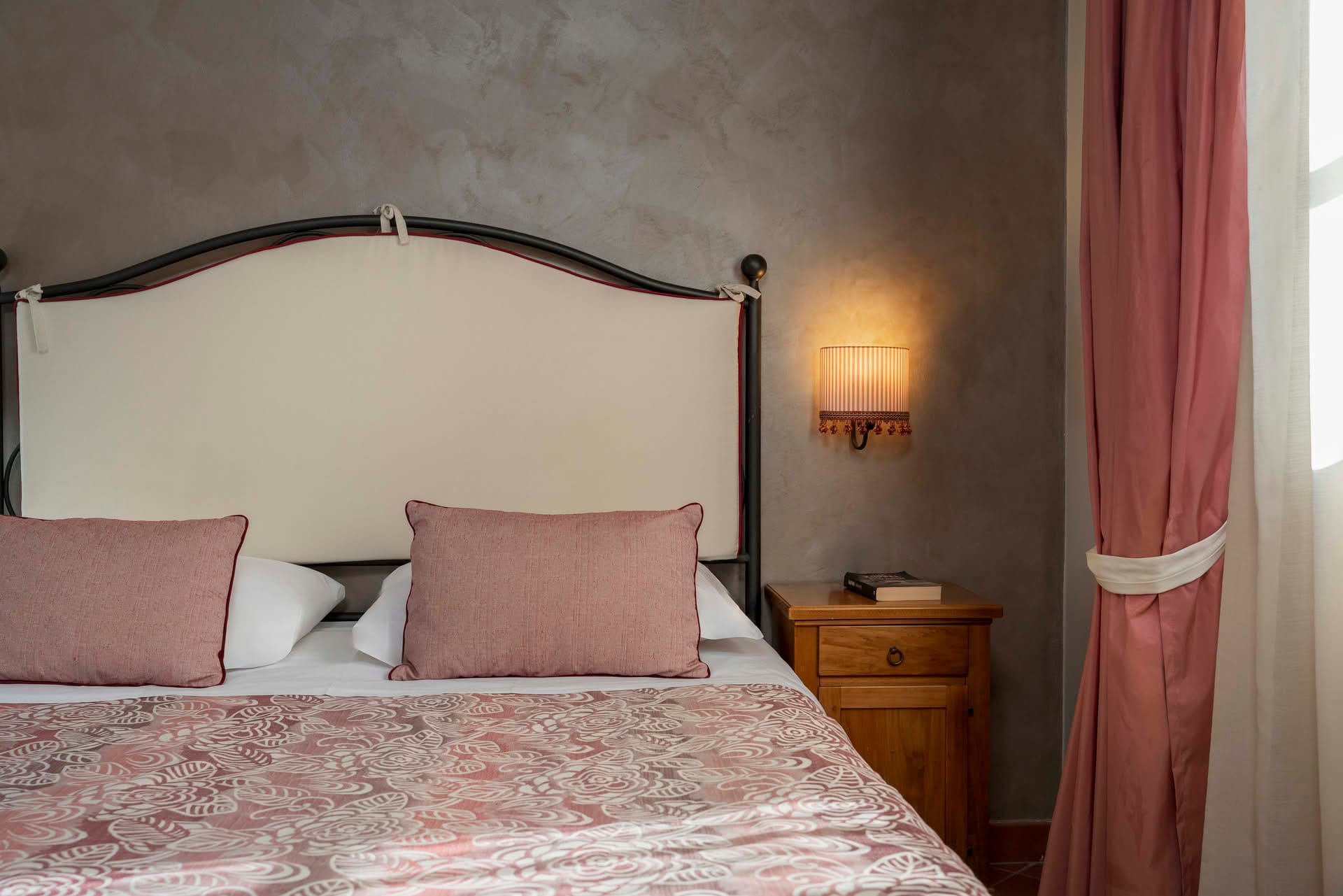 Detail of the double bed with bedside table in the Family Room at Casolare Terre Rosse