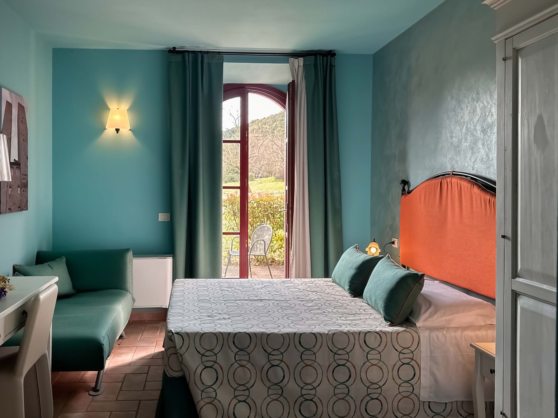 Double bedroom with French door overlooking the garden in the Cipresso Apartment