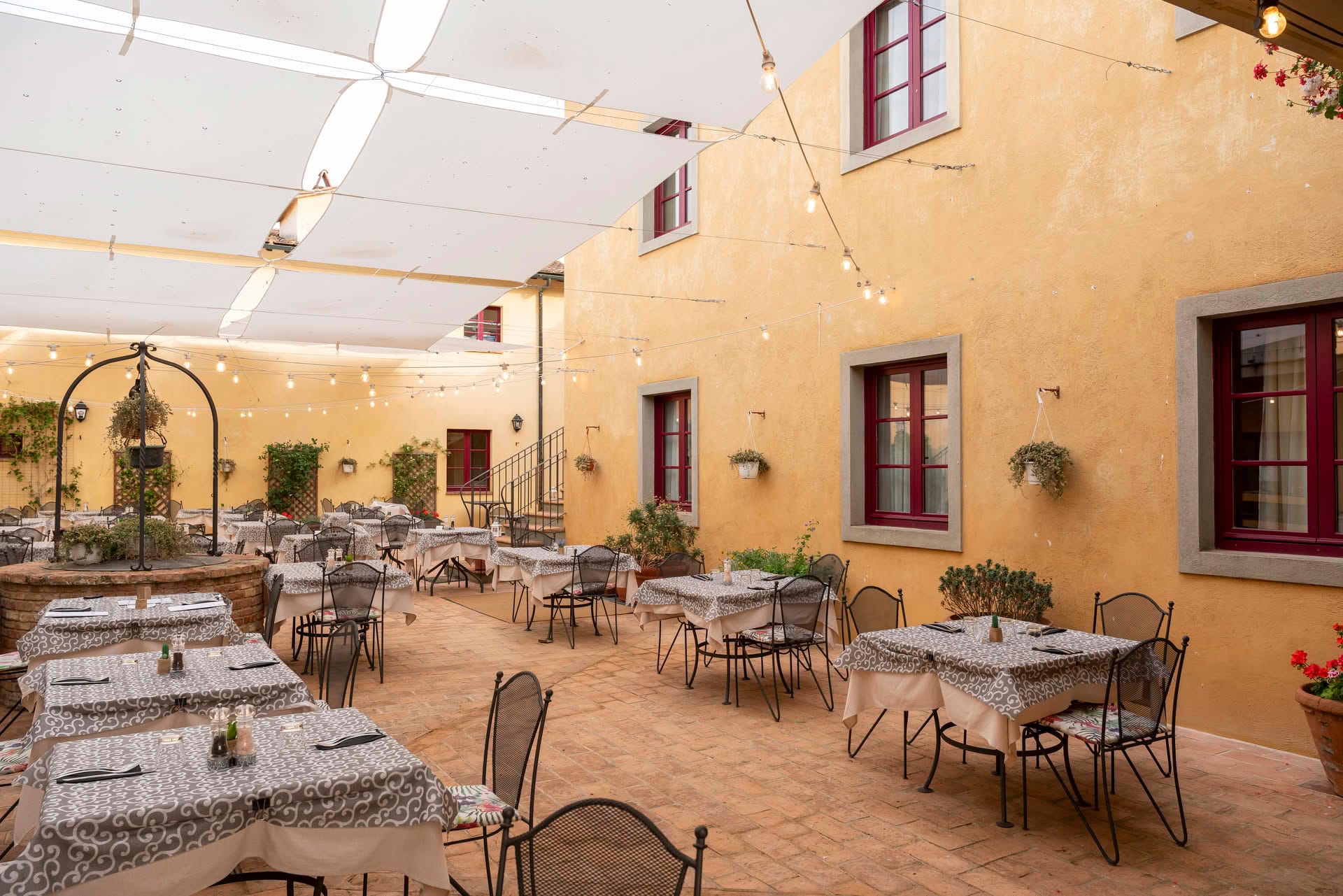 Outdoor courtyard with set tables at the Casolare Terre Rosse Restaurant