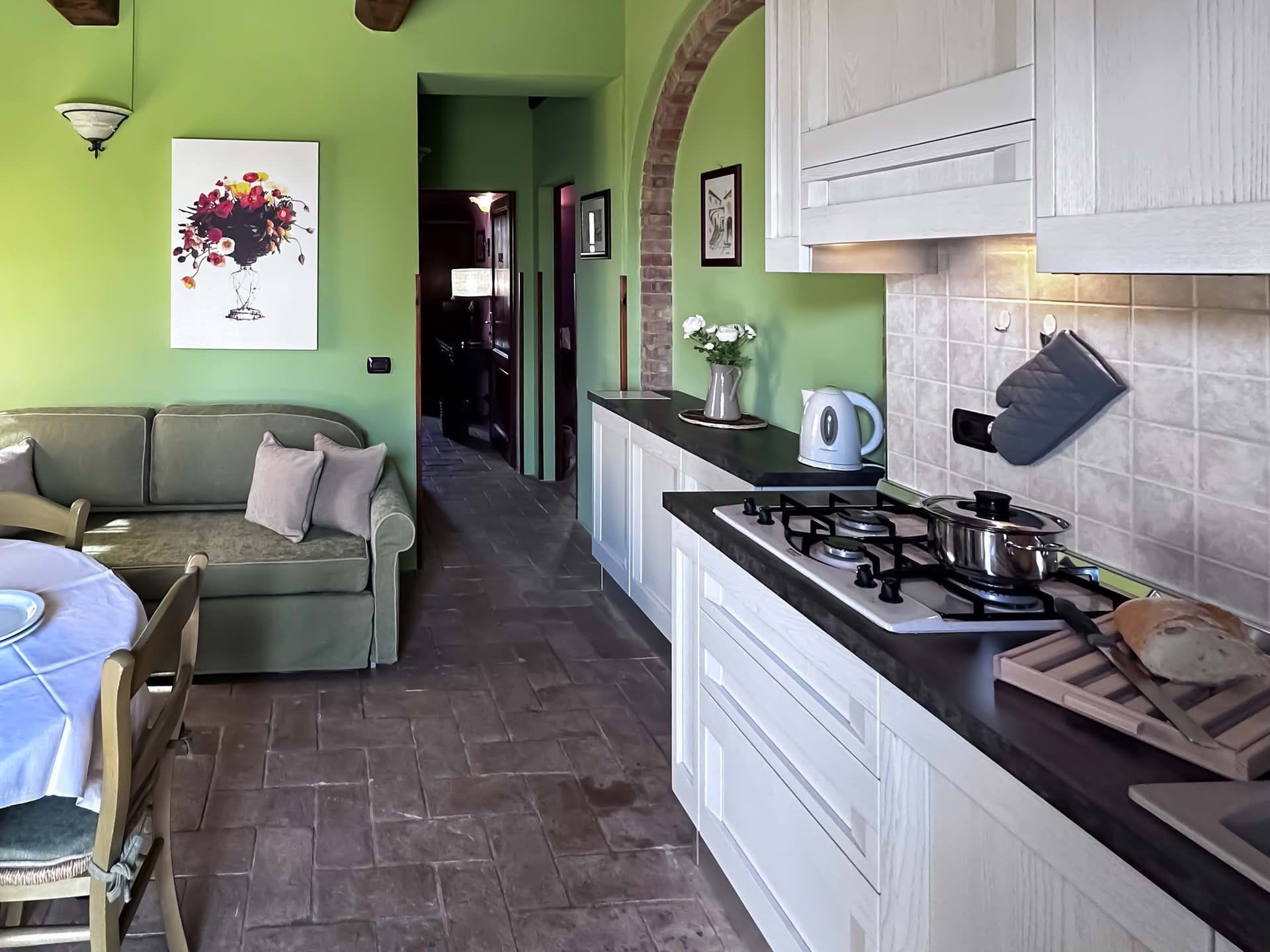 Eat-in kitchen with dining table and sofa in the Quercia Apartment
