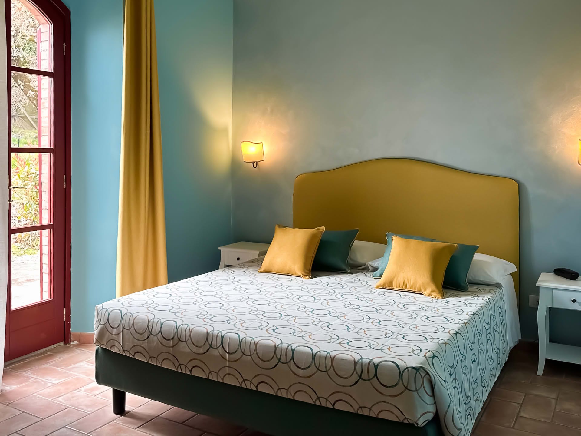 Double bedroom with French door overlooking the garden in the Olivo Apartment